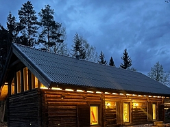 Guļbūves māja vakarā ar apgaismojumu