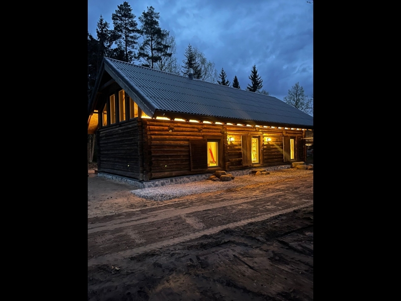 Guļbūves māja vakarā ar apgaismojumu