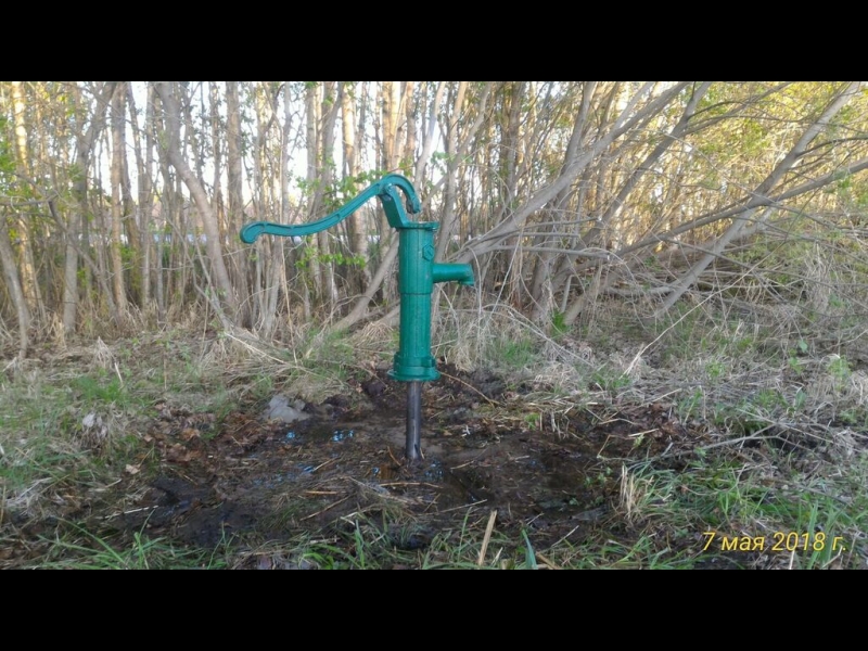 Rokas ūdens pumpis uz spices akas dārza