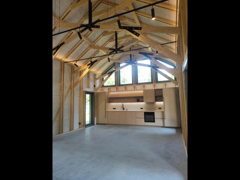 Moderns koka mājas interjers ar augstiem griestiem un sijām