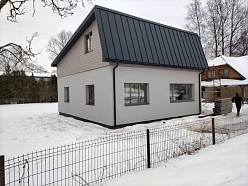 Privātmāja ar metāla jumtu ziemas apstākļos