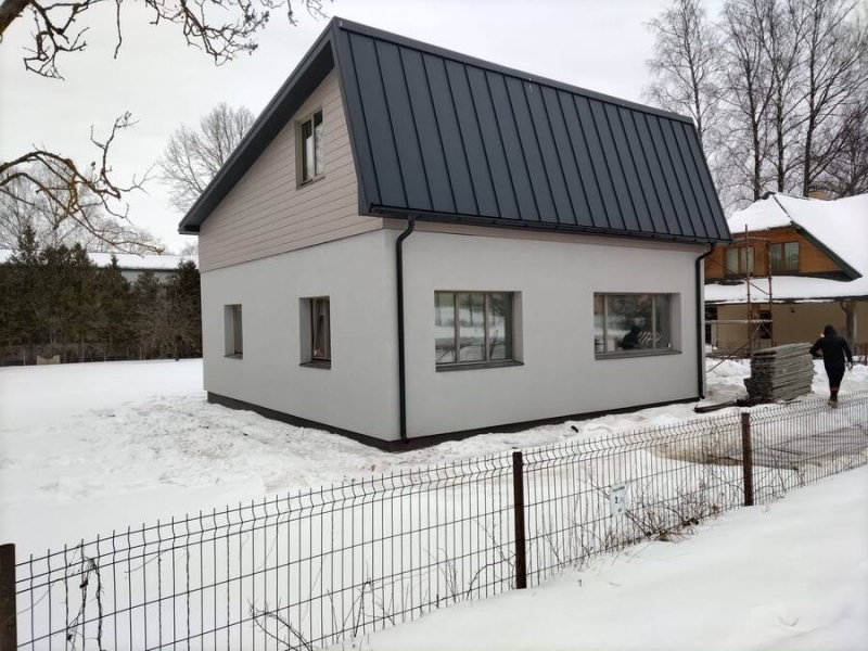 Privātmāja ar metāla jumtu ziemas apstākļos
