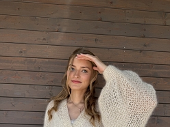 Komforts un elegance rokadītā baltā džemperī.