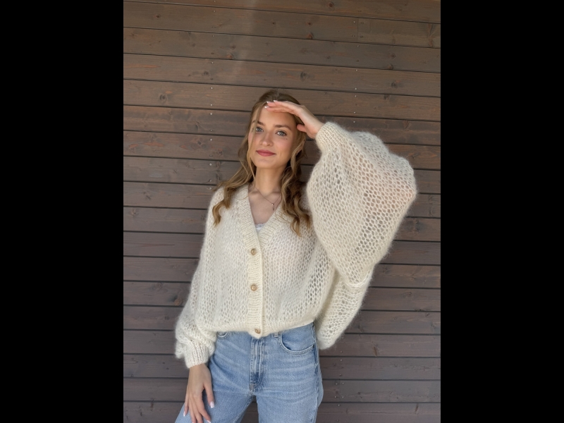 Komforts un elegance rokadītā baltā džemperī.