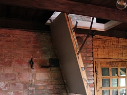 Koka kāpnes un kamīns koka mājas interjerā