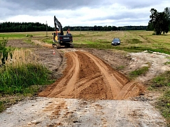 "Valmieras ceļi" ekskavators strādā pie grants ceļa būvniecības lauka Vidzemē