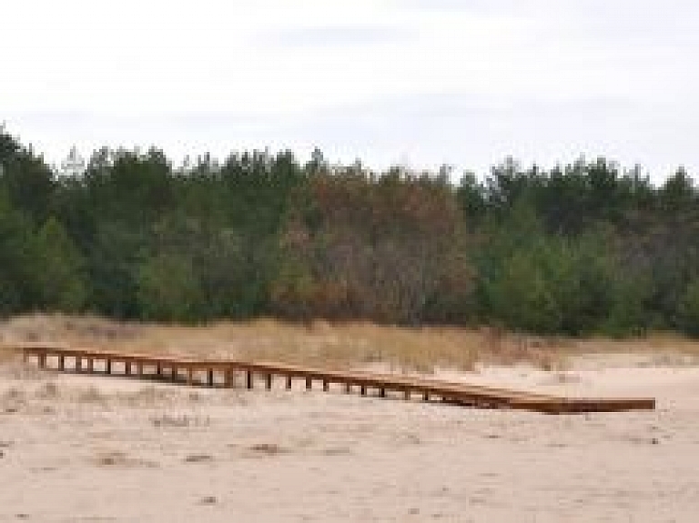 Lilastē tapis celiņš, nodrošinot pieeju pludmalei cilvēkiem ratiņkrēslā